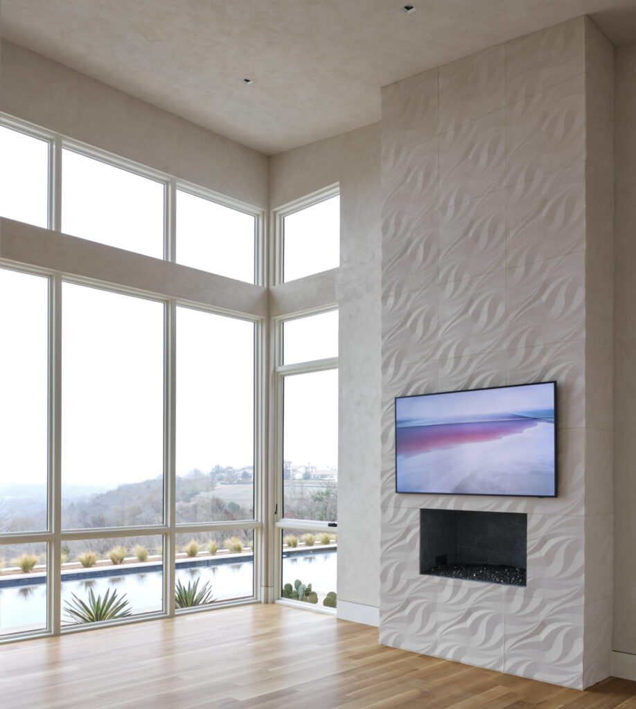 Tile on fireplace surround with wood floors and floor to ceiling windows