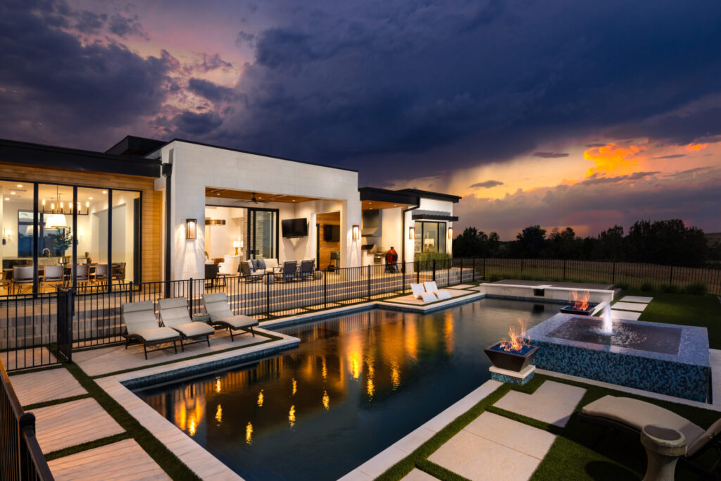 Outdoor setting at night with pool and exterior of modern house