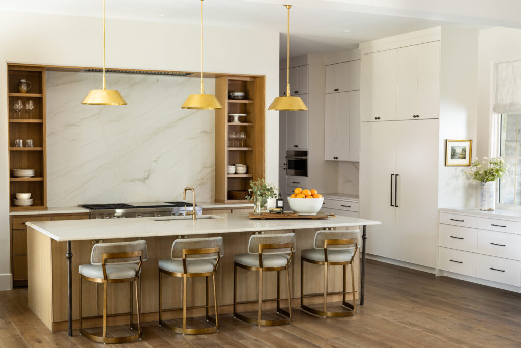 Bright and white kitchen with wood island and shelves and marbled tile walls