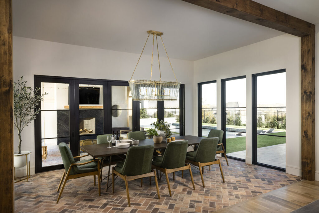 dining room with tiled floor, green chairs, and dark table. Lots of windows
